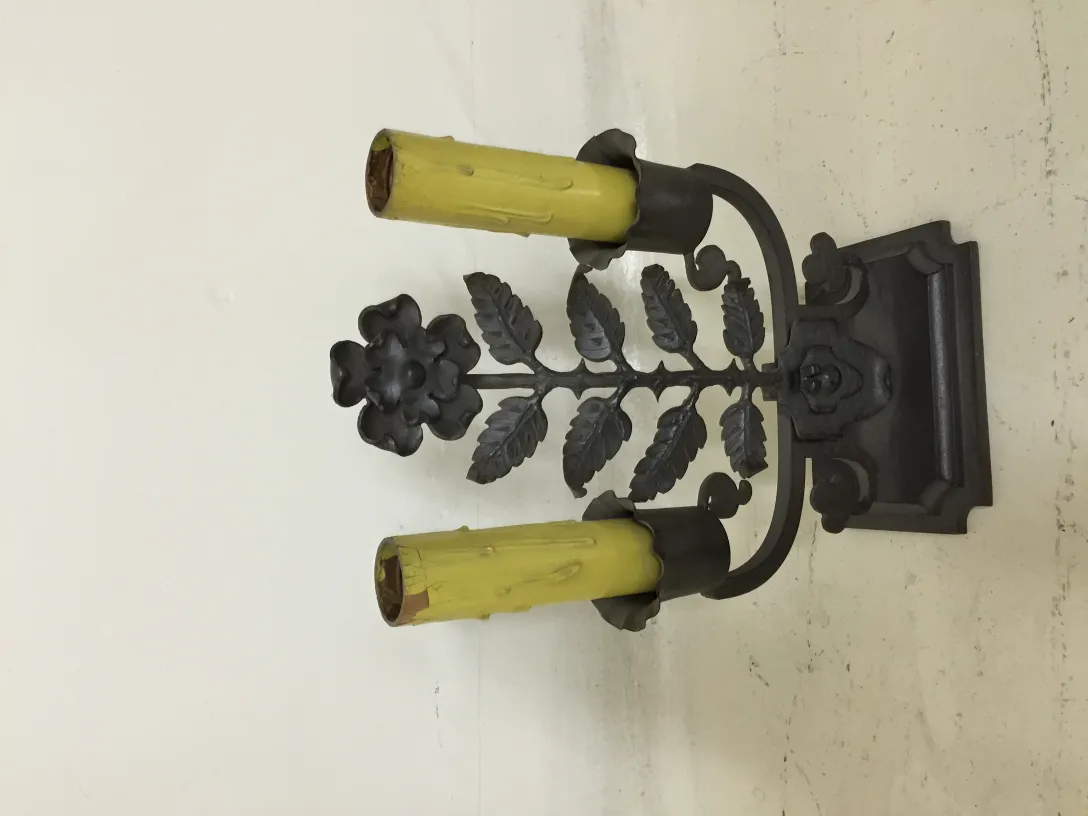 Antike Tischlampe mit dekorativem Sockel und Blume, in einer einfachen Umgebung.