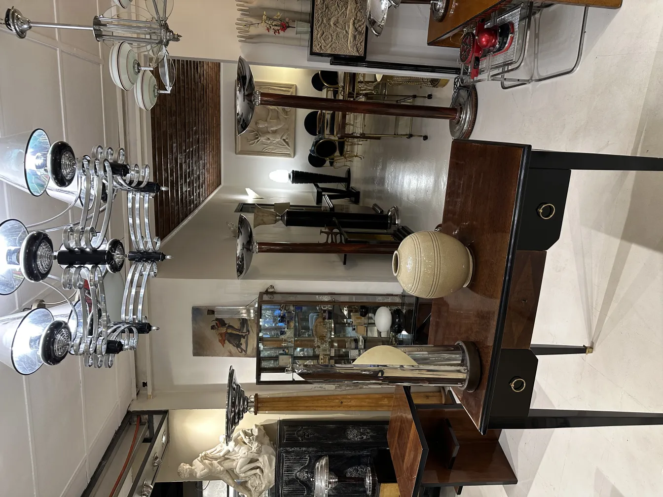 Luminária de mesa antiga com base preta e detalhes decorativos em um ambiente clássico.