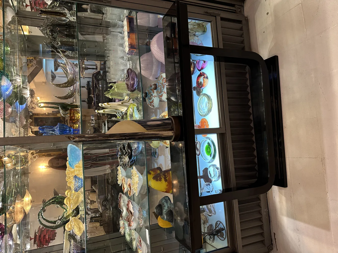 lampe de bureau antique exposée dans une vitrine avec d'autres objets décoratifs