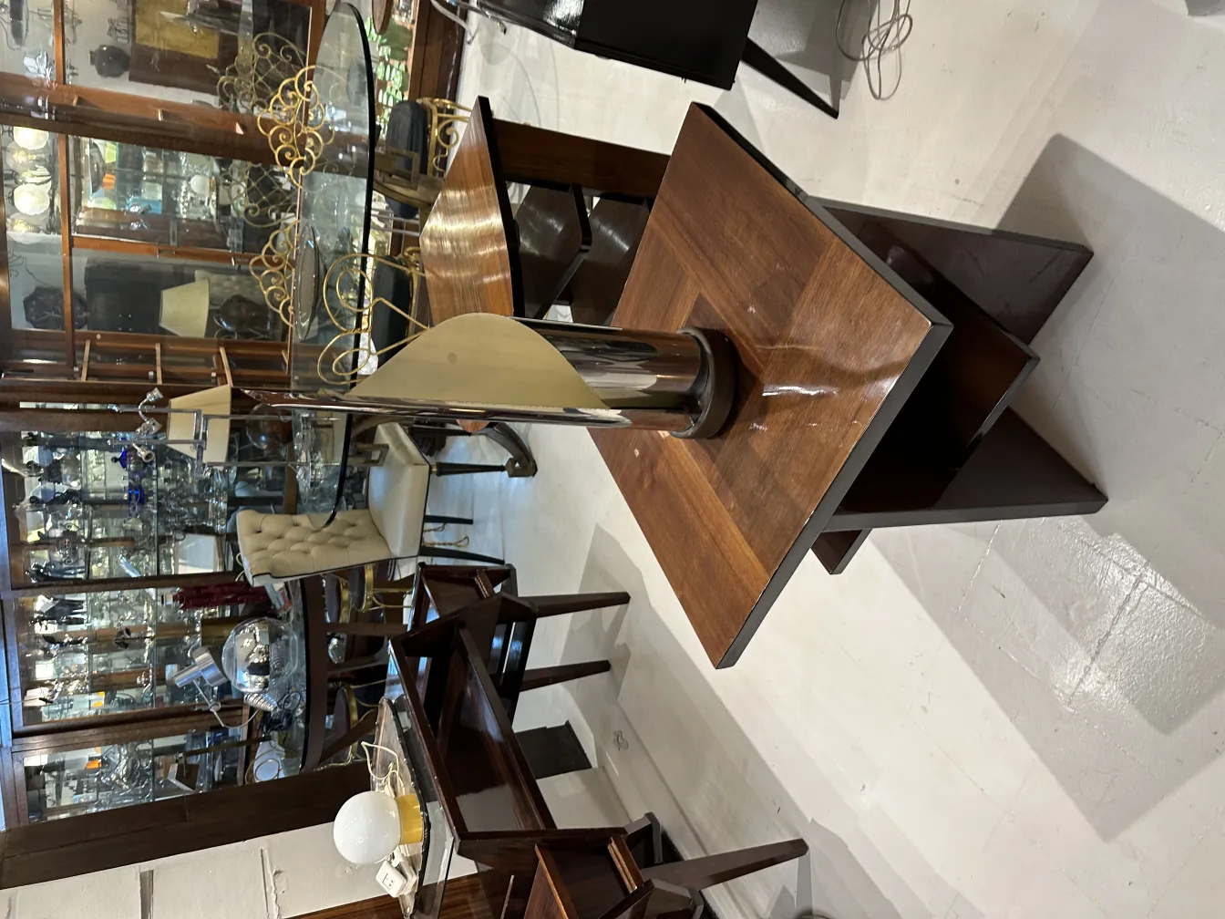 luminária de mesa antiga com base elegante e cúpula clara em um ambiente clássico com móveis de madeira