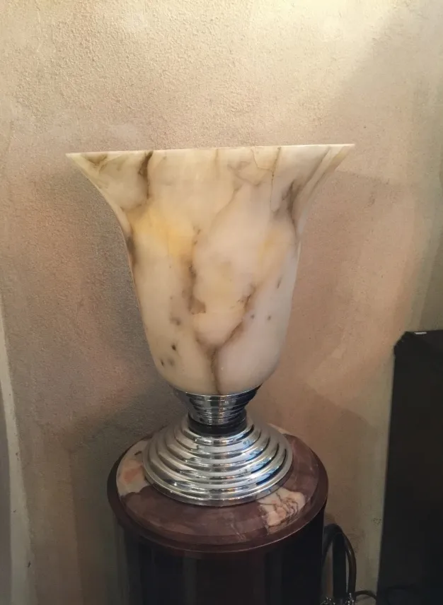 Ancienne lampe de bureau avec base classique et finitions élégantes, ambiance chaleureuse.