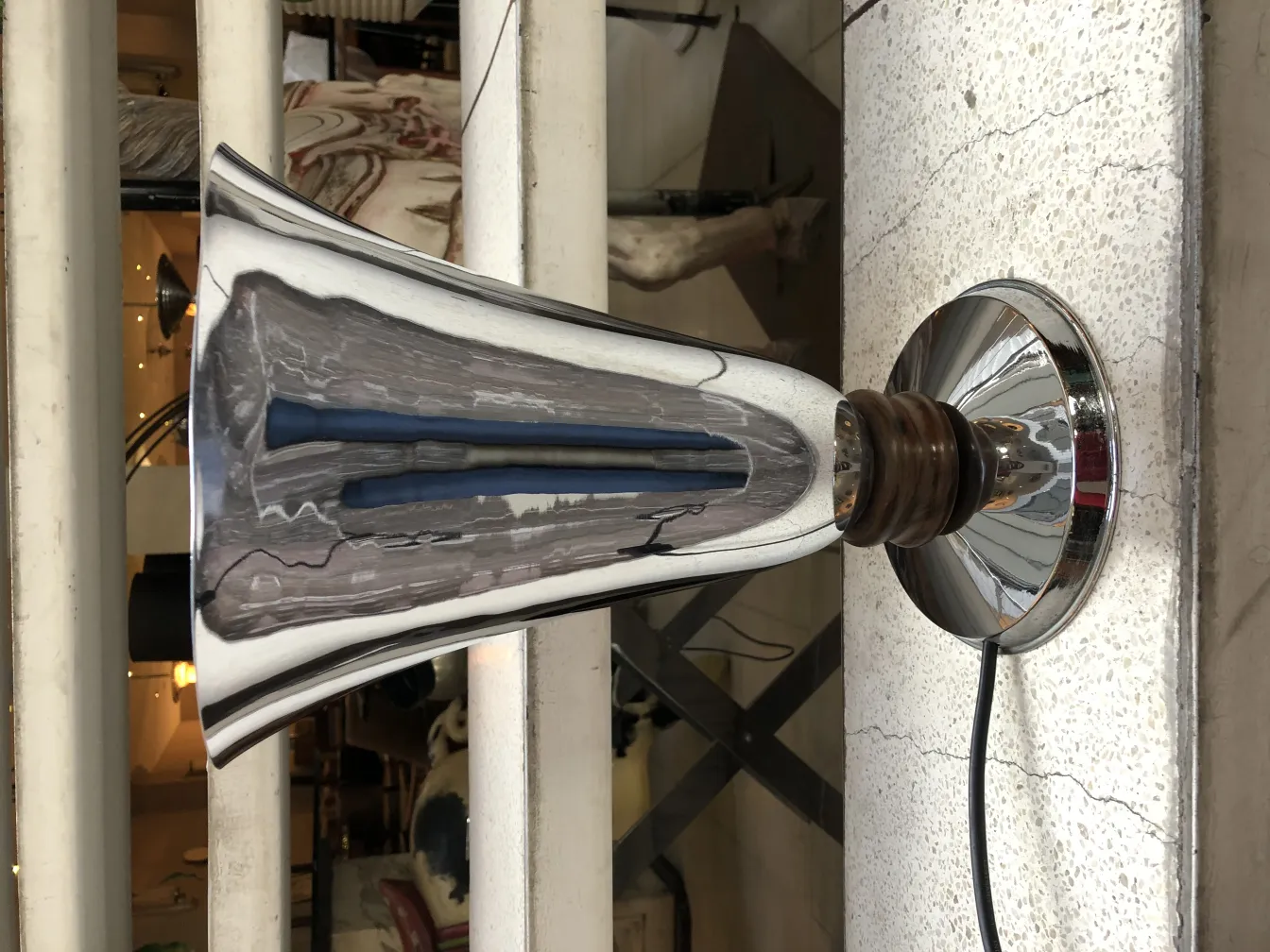 Antike Tischlampe mit glänzender Basis und eleganter Form in einer gemütlichen Umgebung.