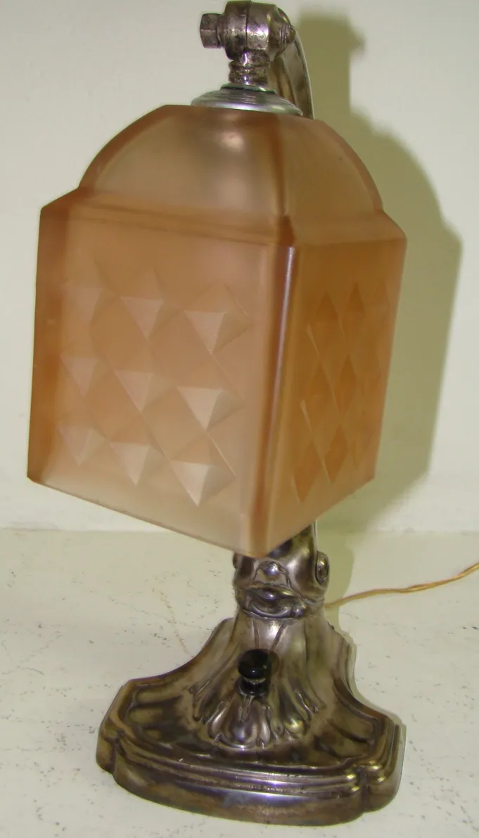 Lampe de bureau ancienne avec abat-jour carré décoratif, ambiance chaleureuse.