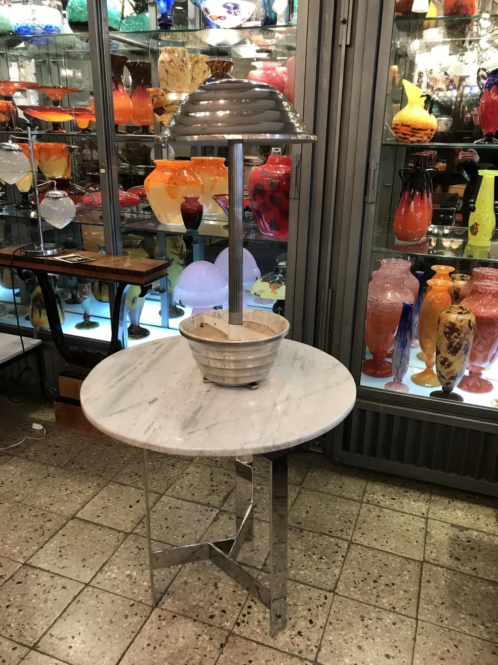 Lámpara de mesa antigua con base decorativa y luz suave en un ambiente elegante.