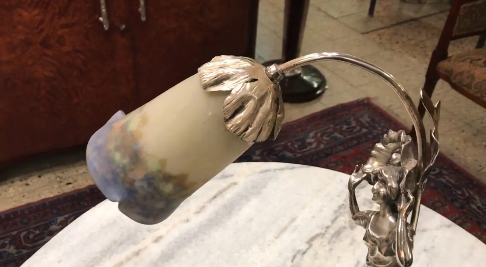 Lampe de bureau antique avec design de feuilles et fleurs dans un environnement accueillant.