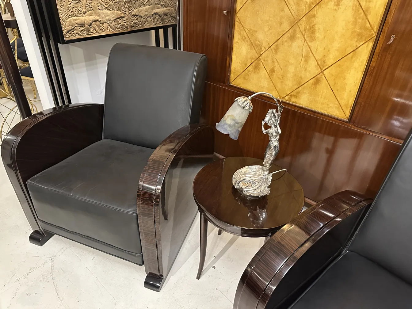 Lámpara de mesa antigua con figura femenina muller fres junto a una mesa y sillones de diseño