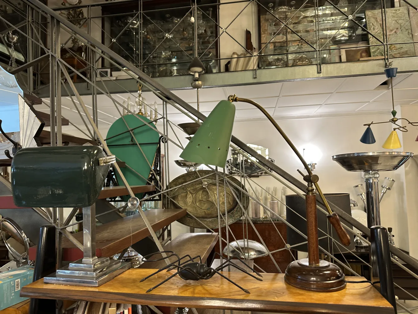 Antiga luminária de mesa verde com design clássico em um ambiente de antiguidades.