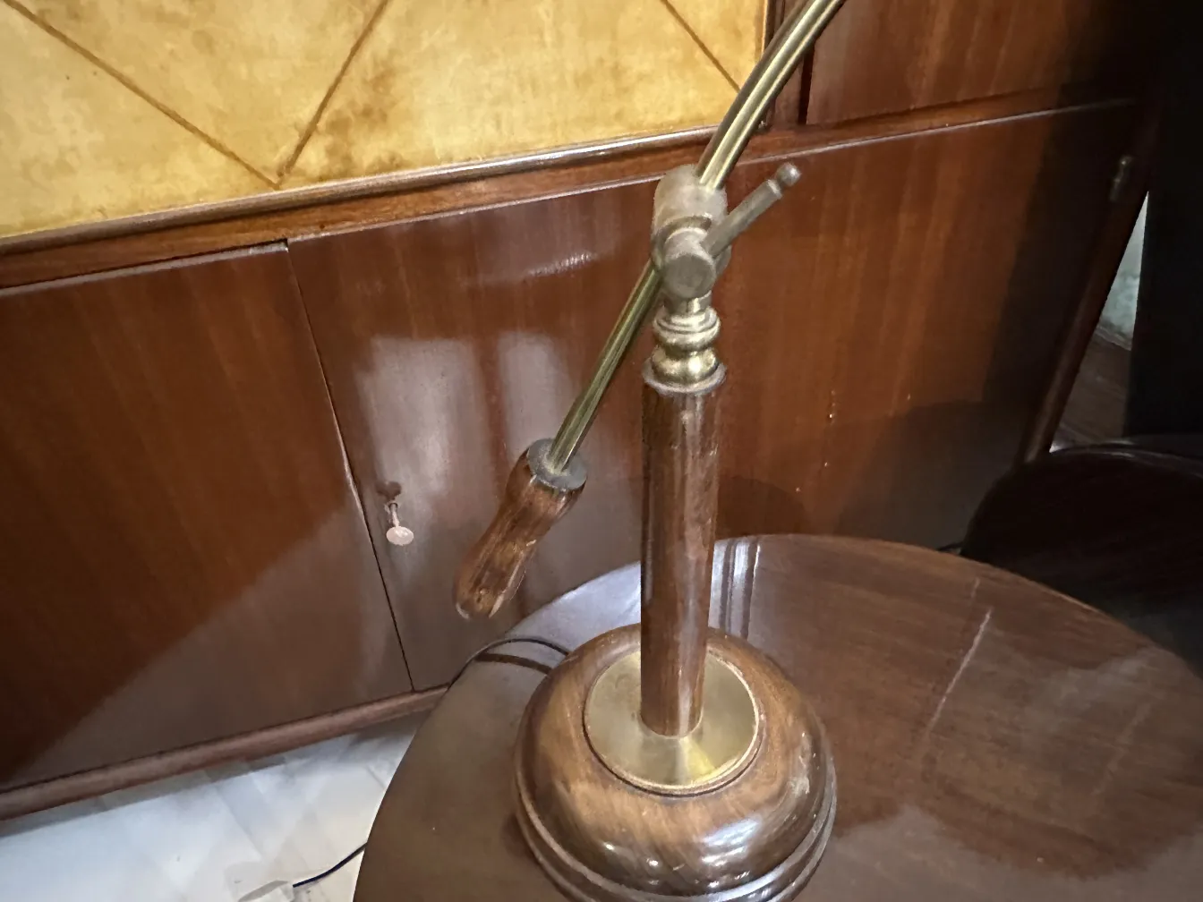 Antigua lámpara de mesa ajustable con base redonda en un ambiente clásico