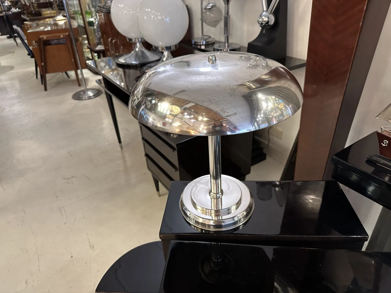 Antike Tischlampe mit glänzender Basis und elegantem Design, in einer gemütlichen Umgebung.