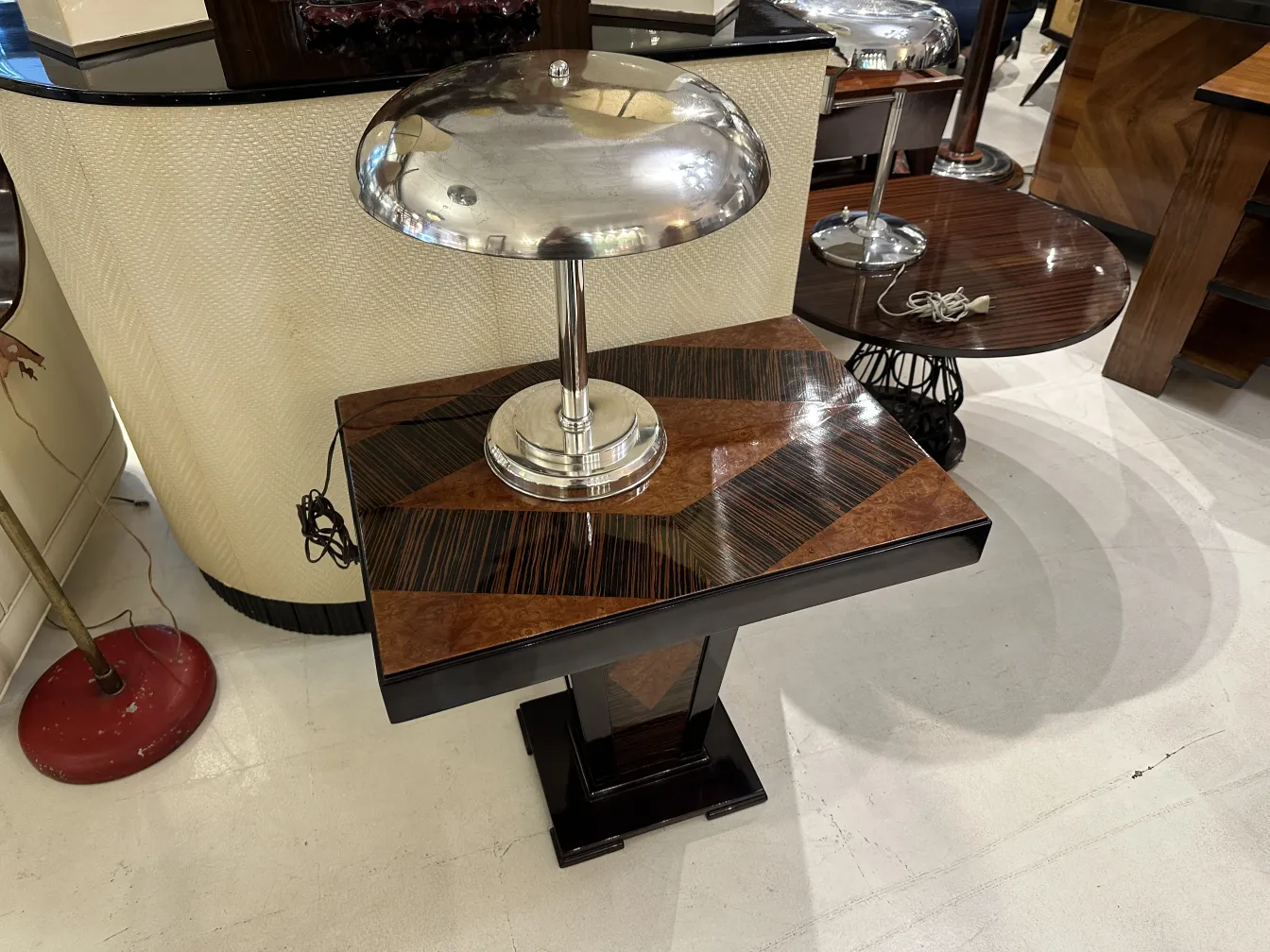 lámpara de mesa antigua con base decorativa y sombra metálica, en un ambiente elegante
