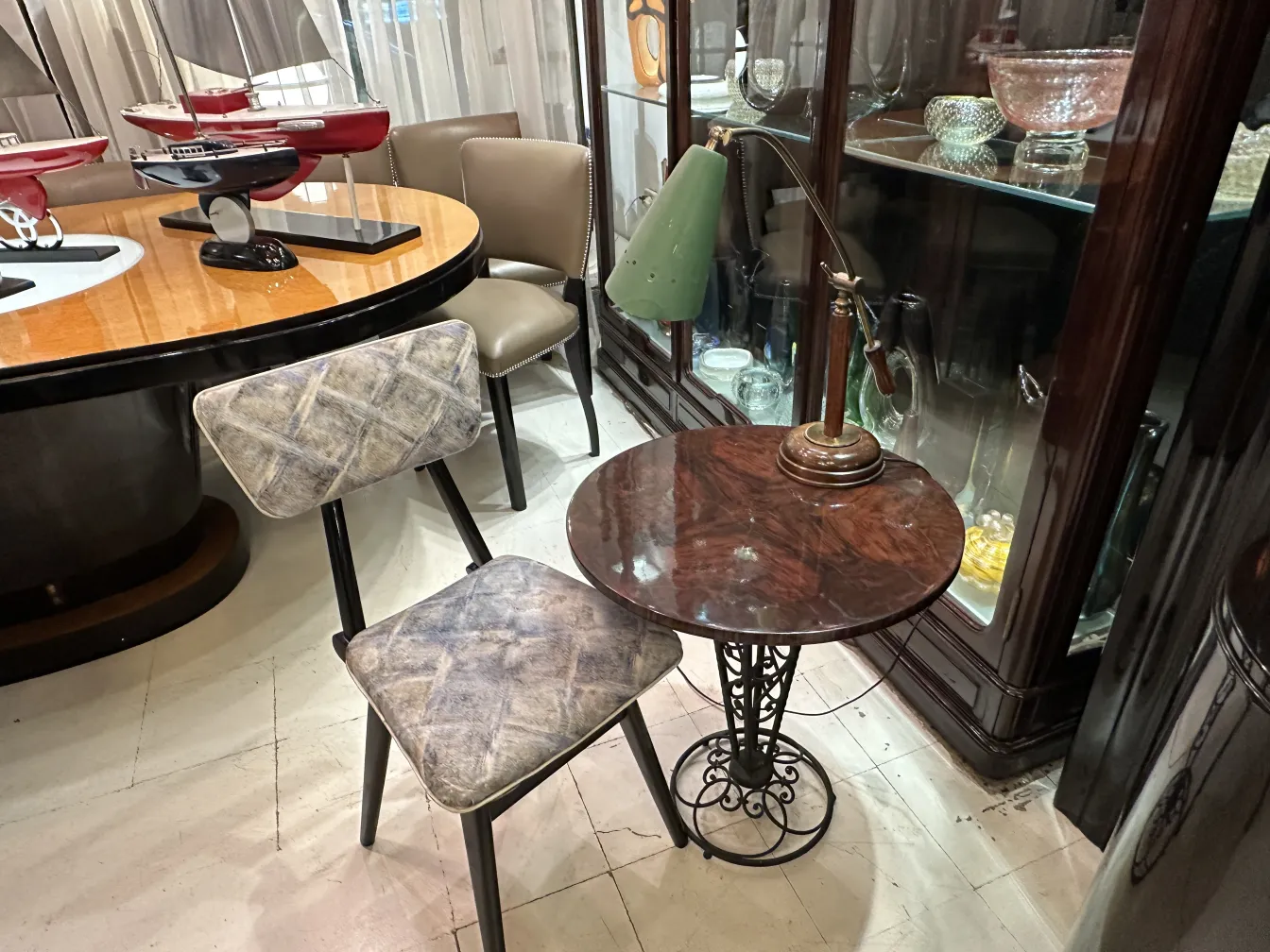 Antique table lamp featuring green shade and metal base, set in an elegant environment.