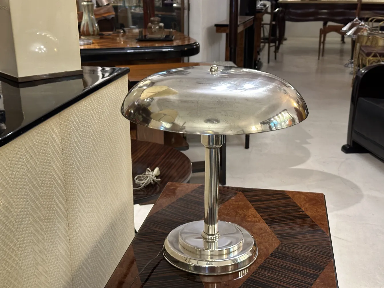 Lámpara de mesa antigua con base brillante y forma elegante. Ambiente acogedor.