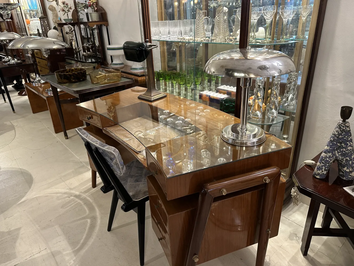 Lampada da tavolo antica con base metallica e parabola curva, stile elegante, atmosfera piacevole.