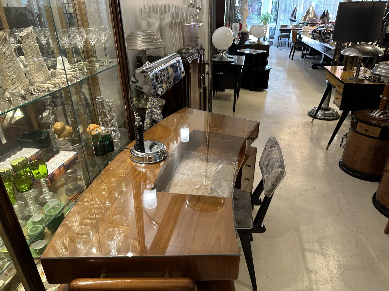 Lampada da tavolo antica su una scrivania con oggetti decorativi.