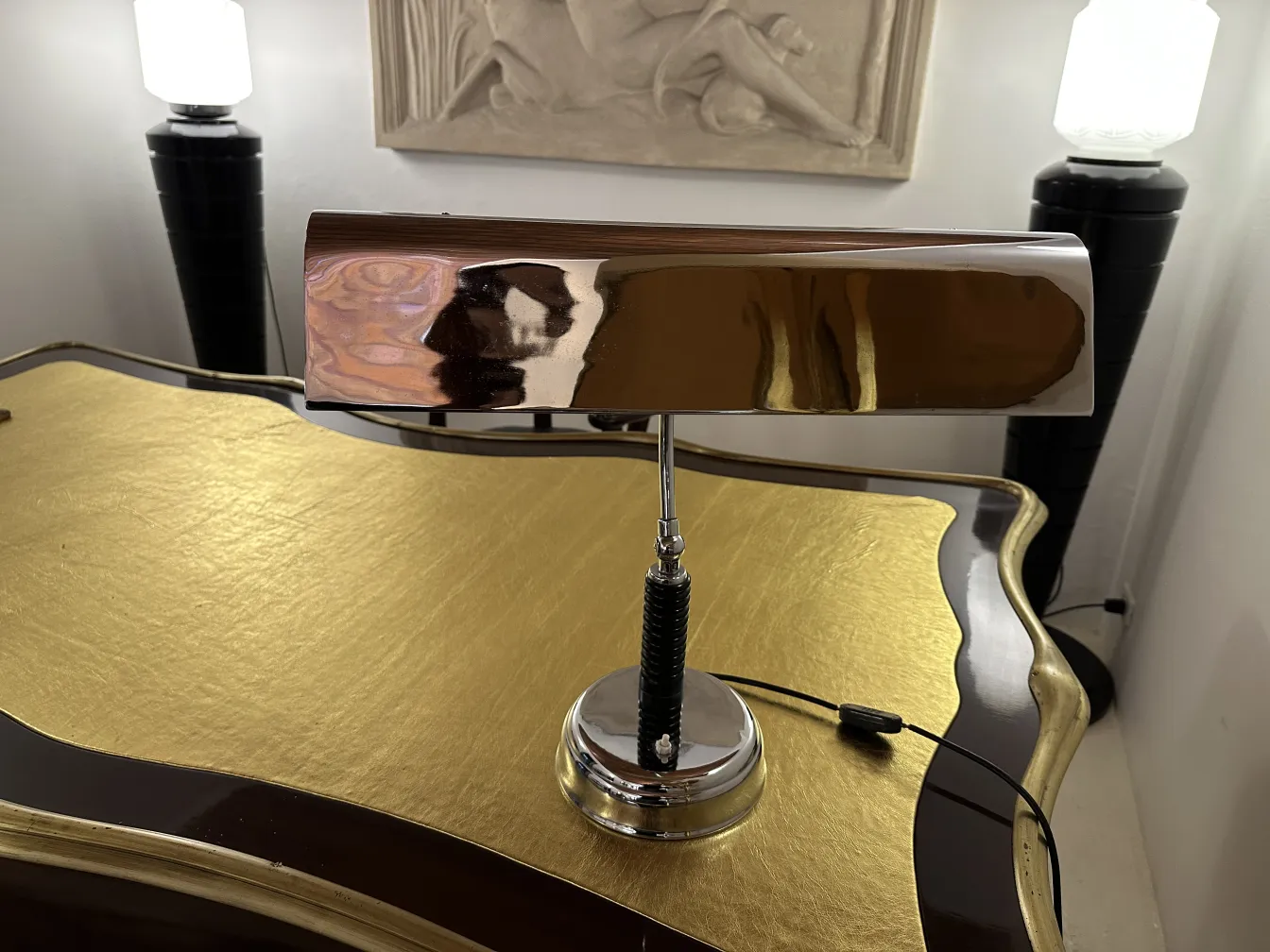 Antique table lamp with a shiny elegant design, illuminating a classic setting.