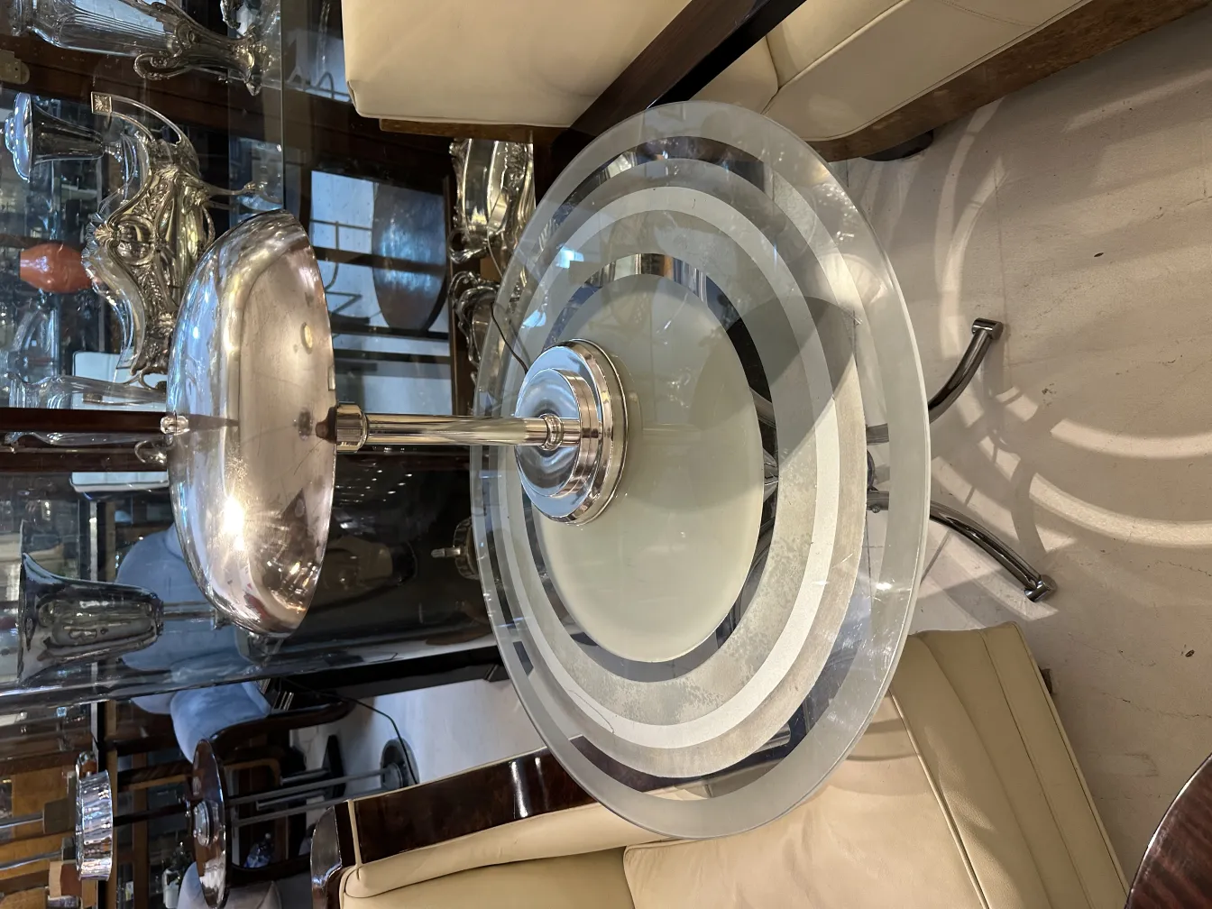 Antike Tischlampe mit silberner Basis und runder Schirm, elegante Atmosphäre.