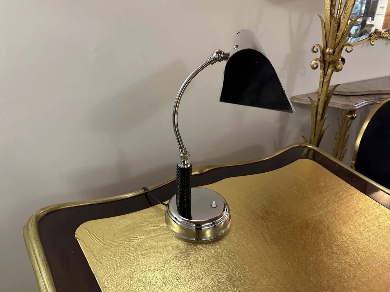 alte schwarze Tischlampe mit verchromtem Sockel auf goldenem Tisch