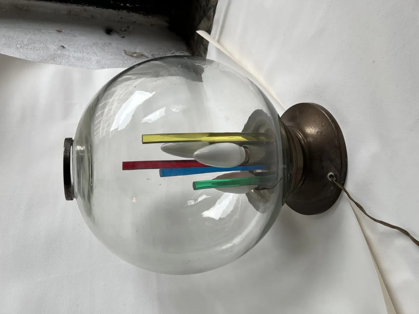 Antike Tischlampe mit Glaskuppel und bunter Dekoration im Inneren, die eine gemütliche Atmosphäre schafft.