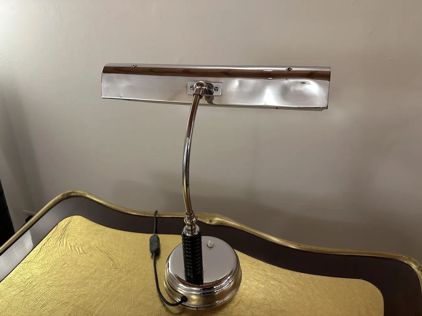 Antike Tischlampe mit geschwungenem Körper und runder Basis, elegante Atmosphäre.