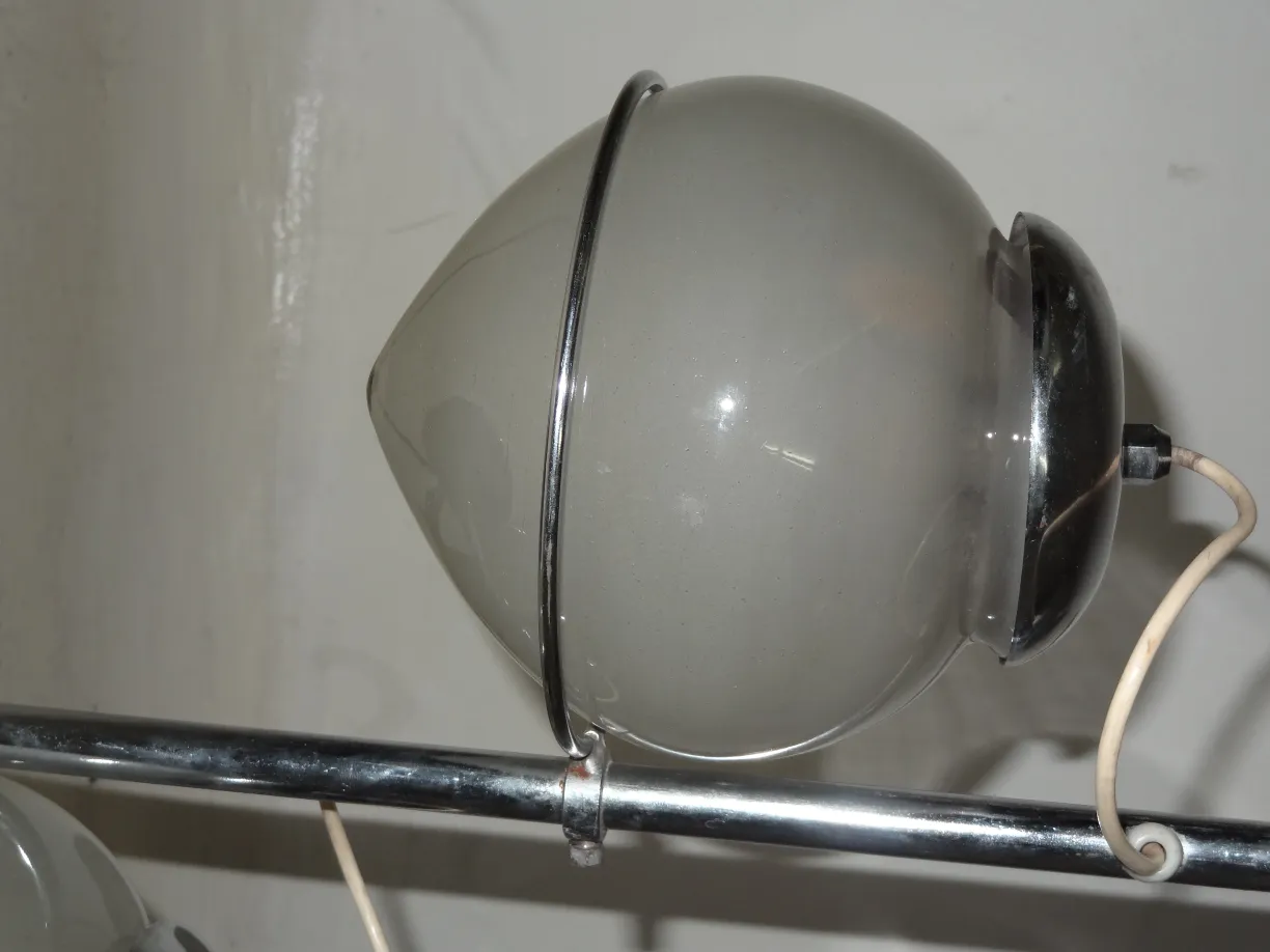 Antique table lamp with spherical design and classic style, in a neutral background.