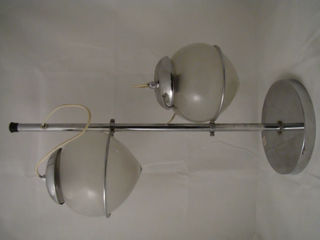Lampe de bureau ancienne avec deux globes lumineux sur un support, dans un environnement neutre.