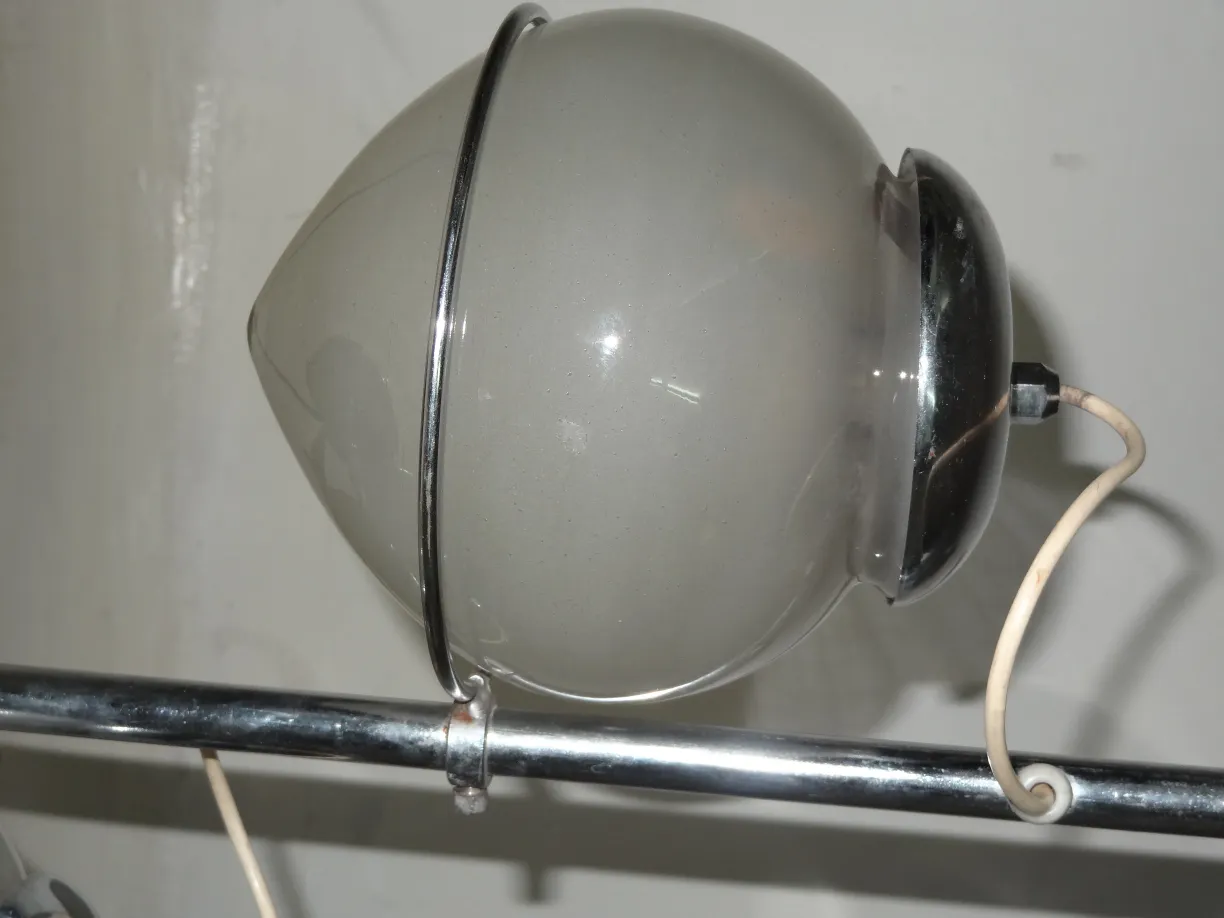 Lampada da tavolo antica con forma sferica e dettagli metallici, ambiente minimalista.