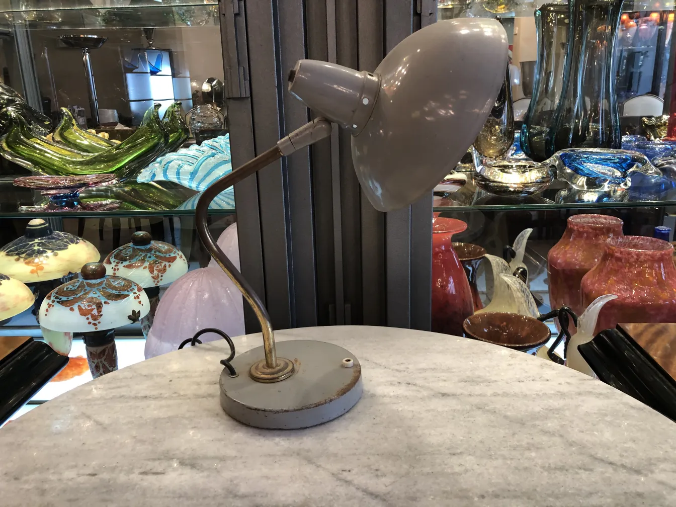 Lampe de bureau ancienne avec base ronde, décorative, dans un cadre rempli d'antiquités