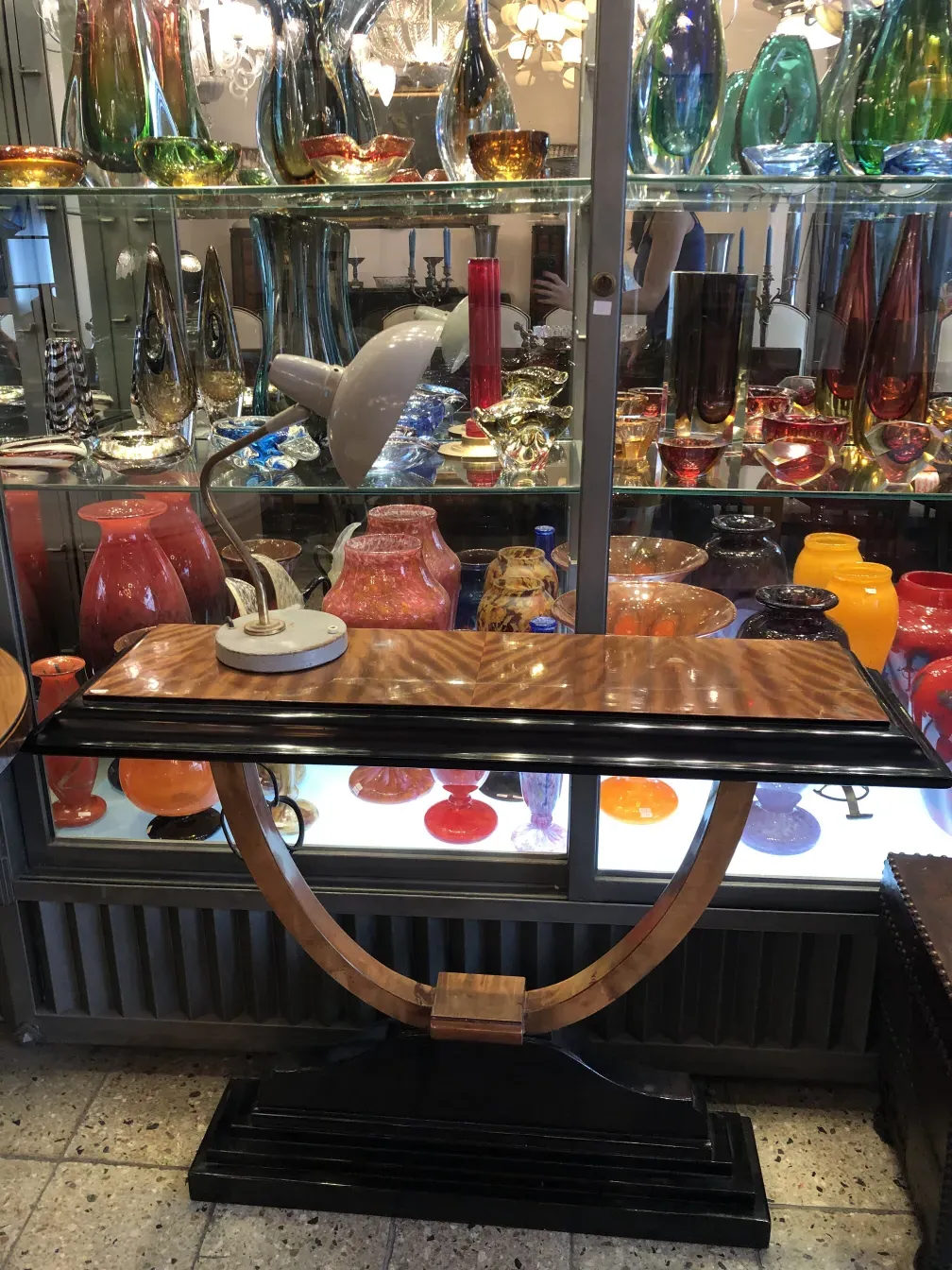 Antique table lamp by Serge Mouille displayed among colorful glassware