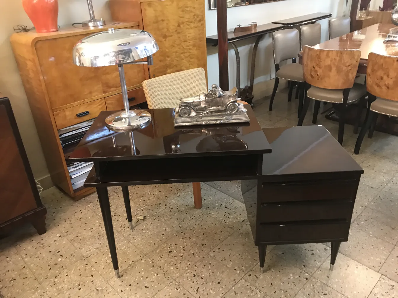 Antique table lamp with a glossy finish on a desk, in an elegant cozy setting.