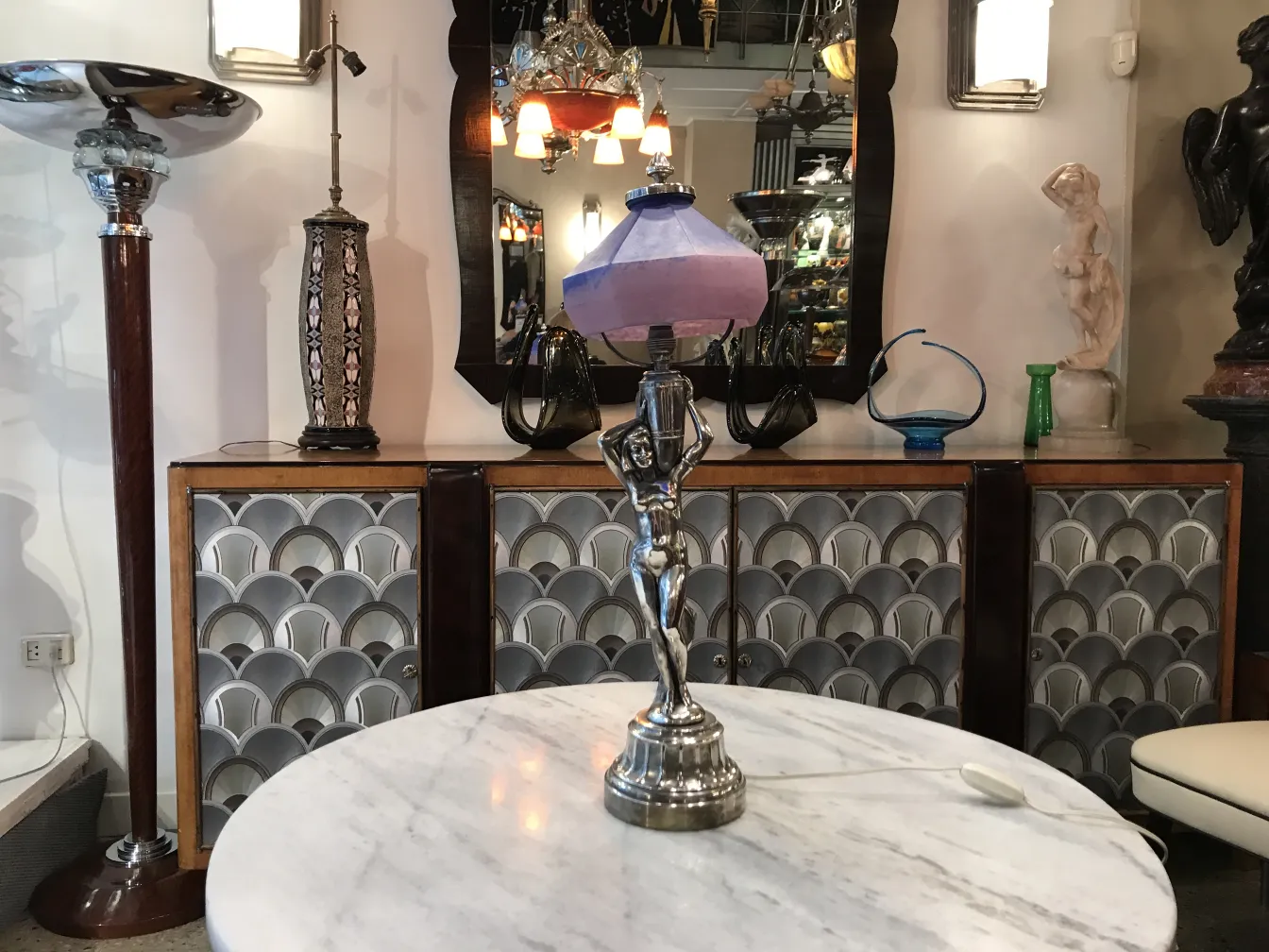 Lámpara de mesa antigua con base de figura, ambiente elegante.