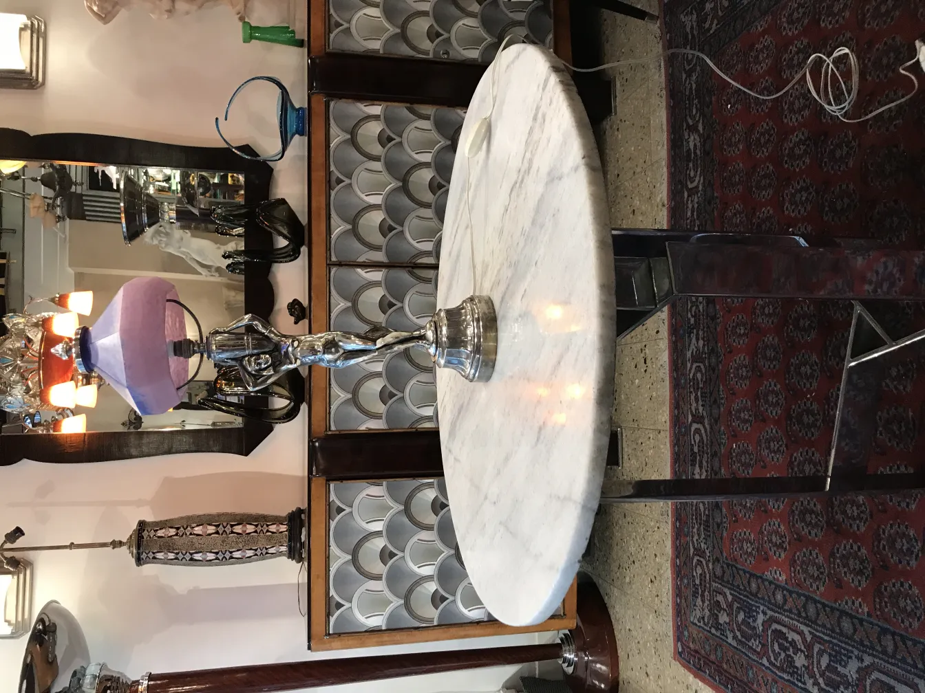 Antique table lamp with lavender shade and decorative base.