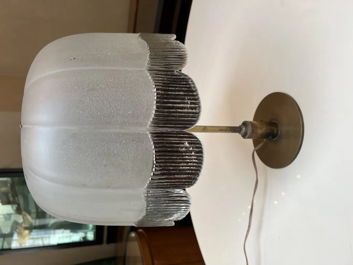 Lampada da tavolo antica con paralume in vetro morbido e base circolare.