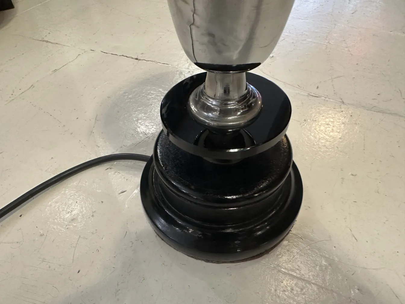 Lampe de bureau antique avec base ronde noire, cadre neutre.