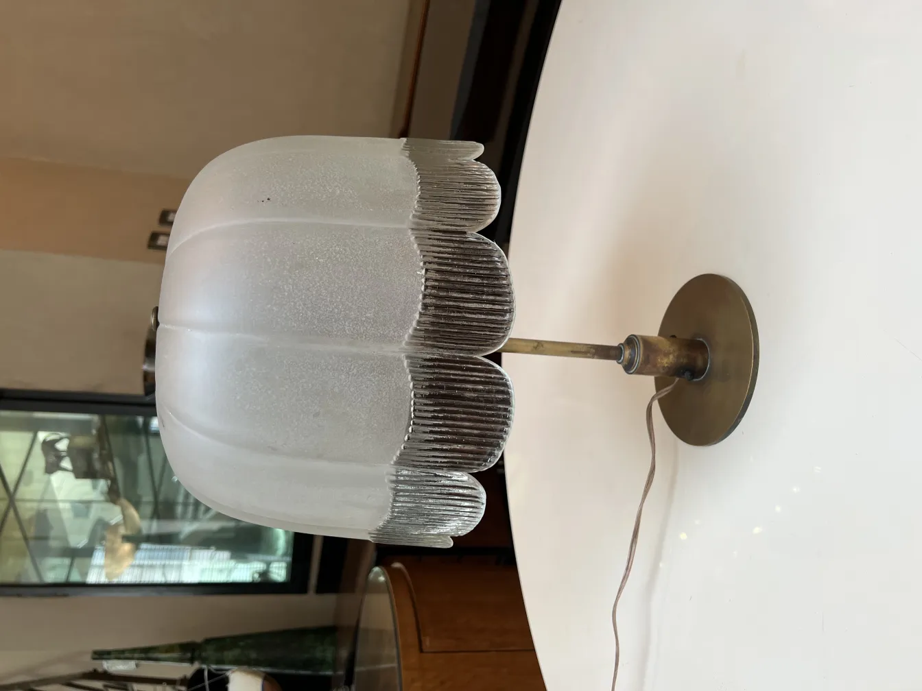 Luminária de mesa antiga com sombra esculpida em ambiente elegante.