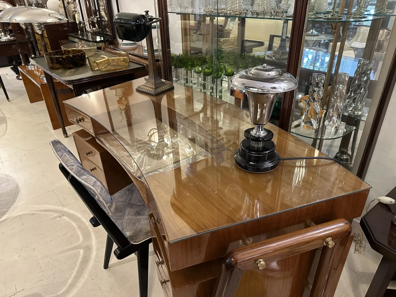 Lámpara de mesa antigua con diseño único sobre escritorio en un ambiente elegante.