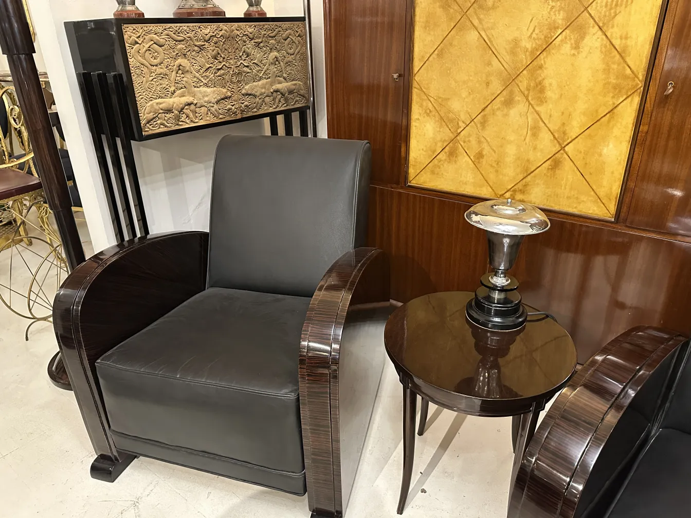 مصباح طاولة قديم على طاولة مستديرة بجانب كرسي.