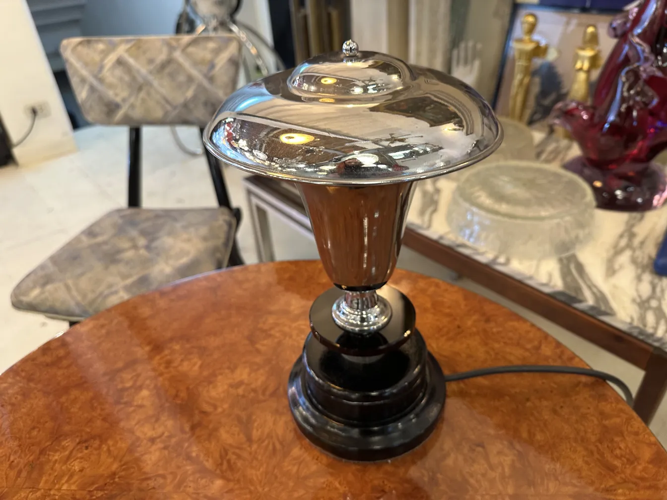 lampada da tavolo antica con base nera e paralume lucido, in un ambiente elegante