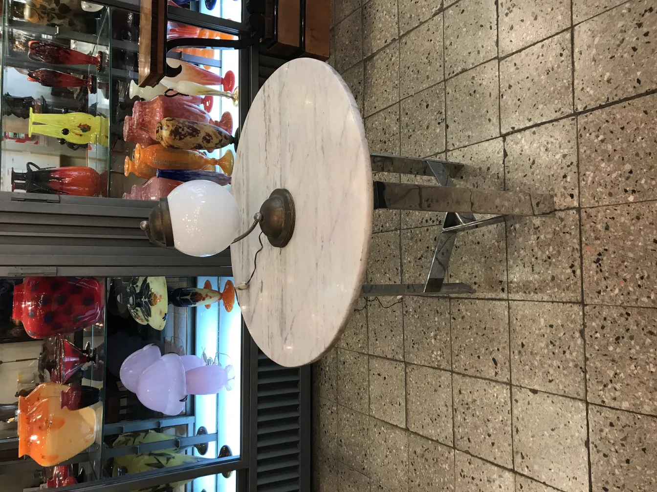 古い金属製のベースと白い球のテーブルランプ、カラフルな花瓶の背景。