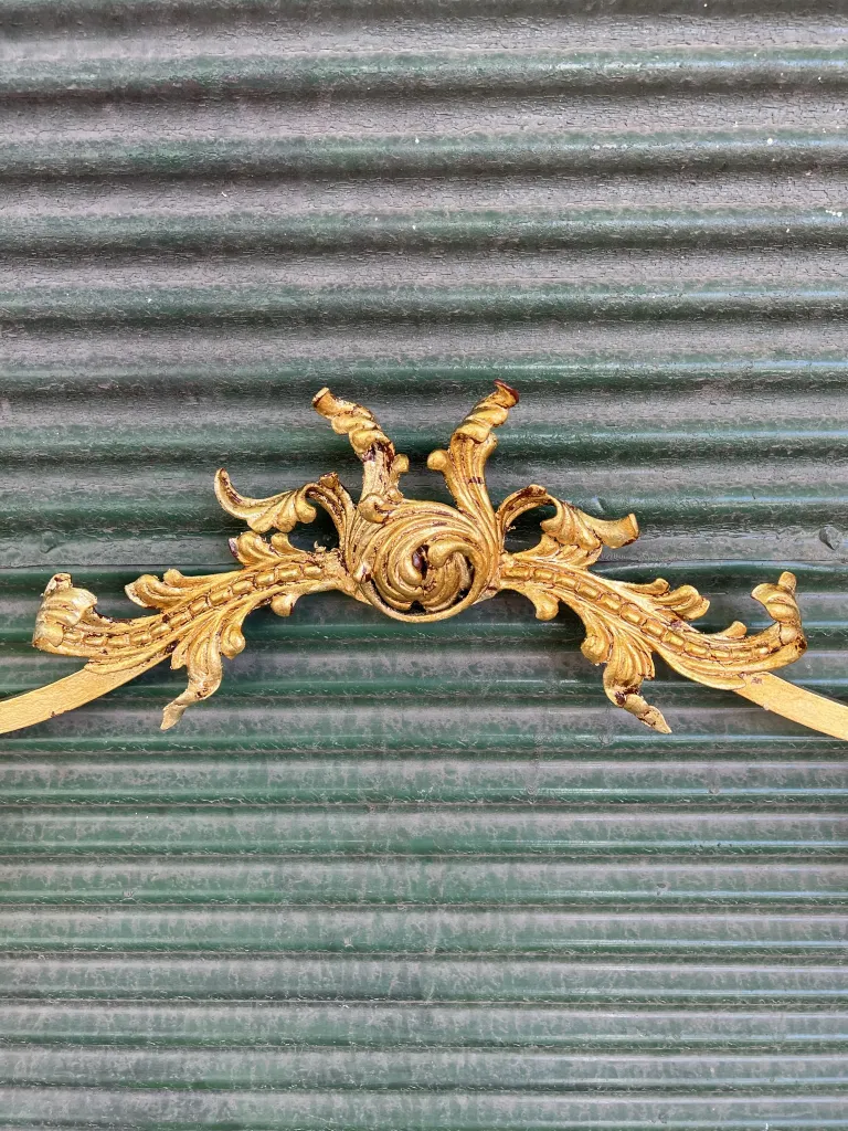 Detalles dorados en consola antigua con diseño ornamental