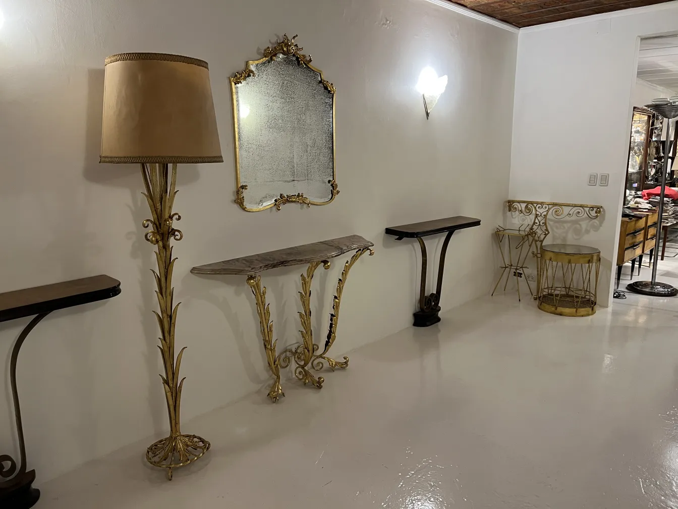 console antica decorata con disegni di foglie dorate e specchio