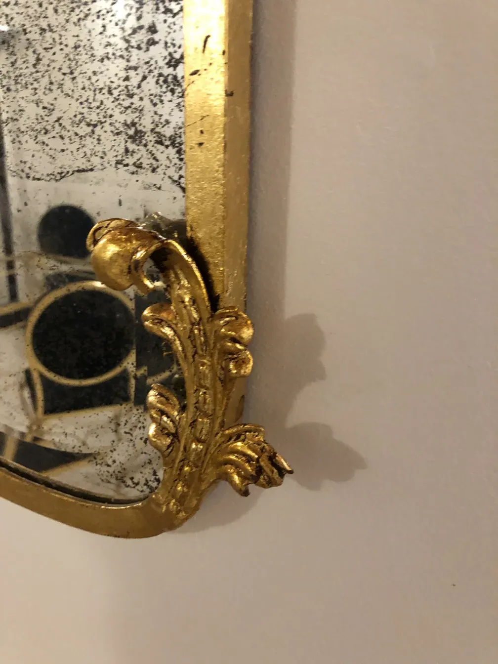 Specchio antico decorato con elementi dorati.