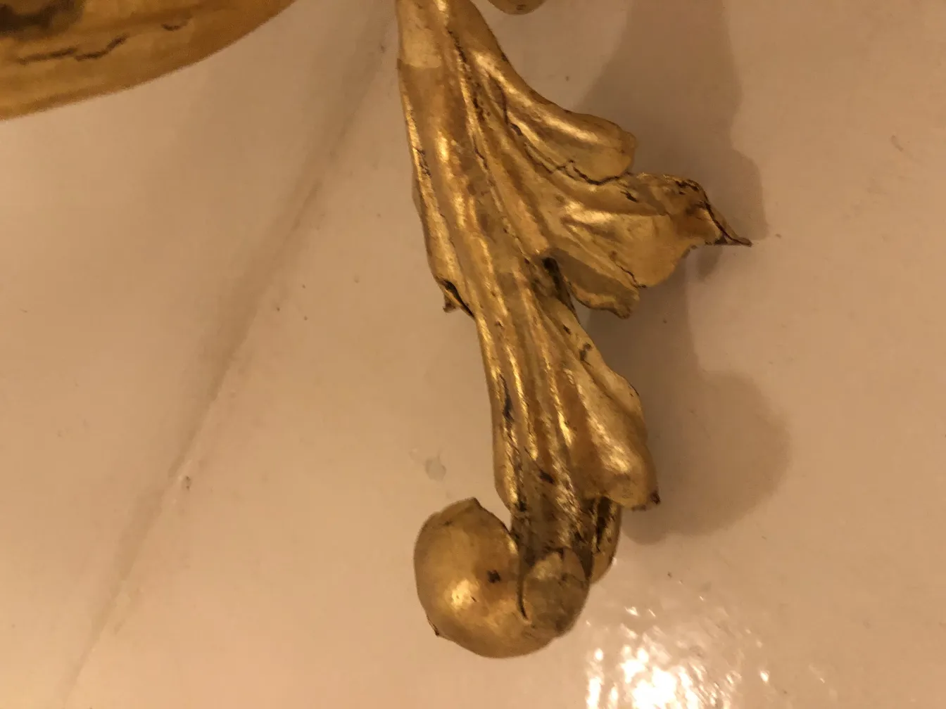 Details eines antiken dekorativen Dresuars mit goldenen Motiven.