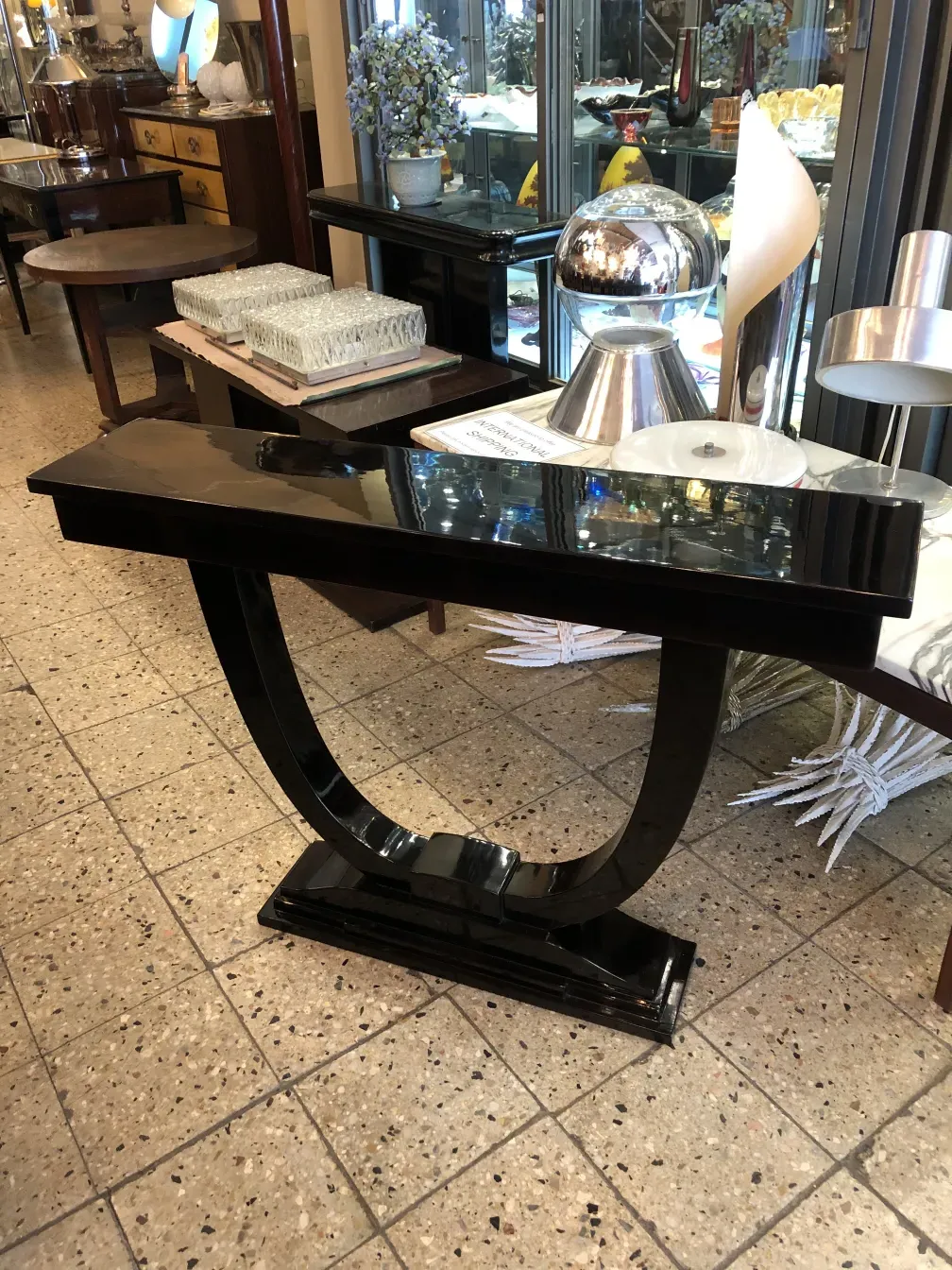 consola antiga com detalhes decorativos, cercada por outros itens em um ambiente elegante