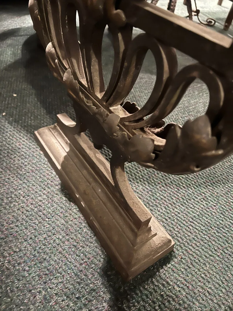 Vue latérale d'une ancienne console décorative avec des détails élaborés.