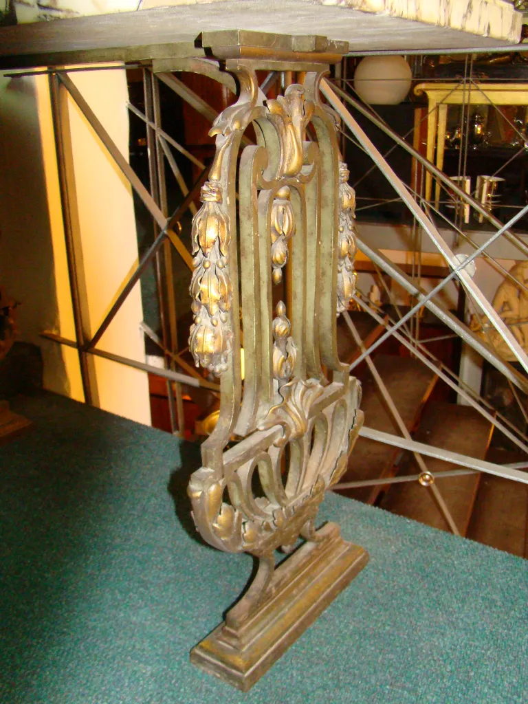 Console ancienne avec des détails décoratifs et un design stylisé.