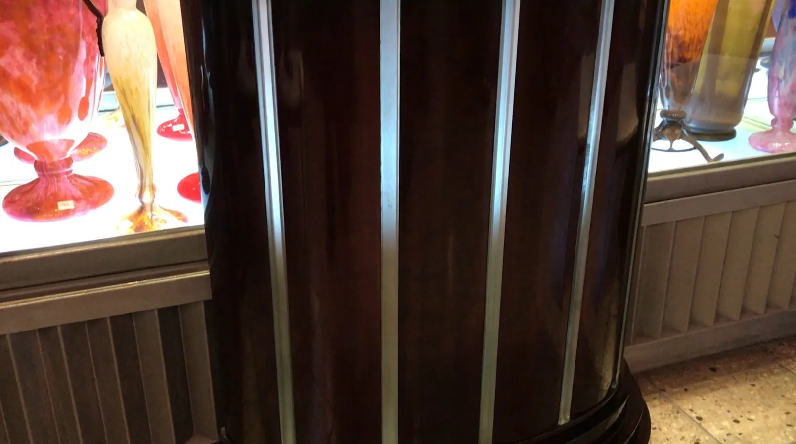 Consola antigua decorativa en un ambiente vintage con objetos de vidrio colorido.