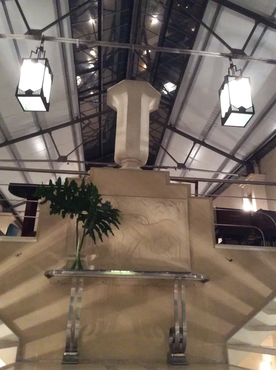 элегантная старинная консоль с зеленью вокруг.