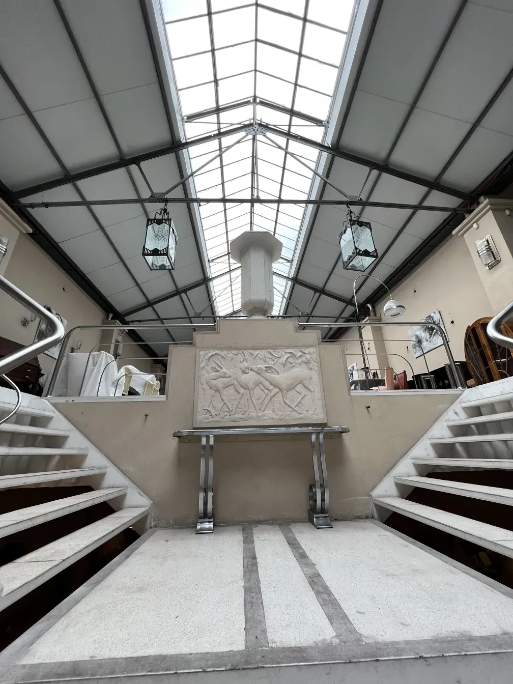 Antico mobili dresuar con rilievo sul davanti, decorativo, in un ambiente spazioso con scale.