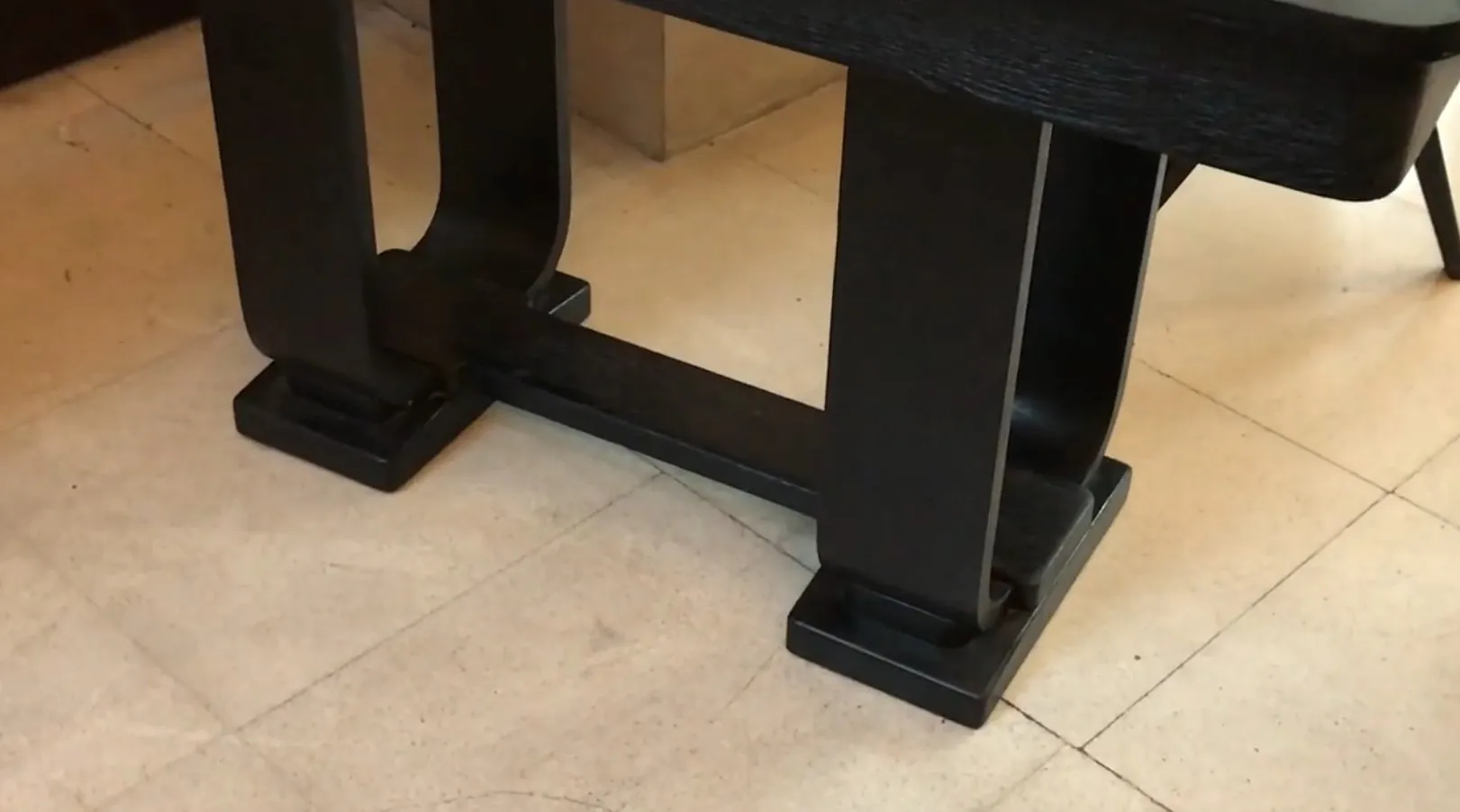 Detalhe de uma consola antiga com construção sólida em um ambiente elegante.