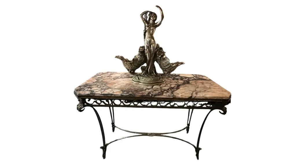 Antique console with decorative figure and detailed finish.